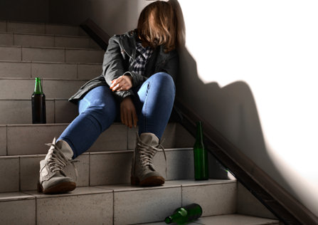 Drunk woman sitting on the staircase.